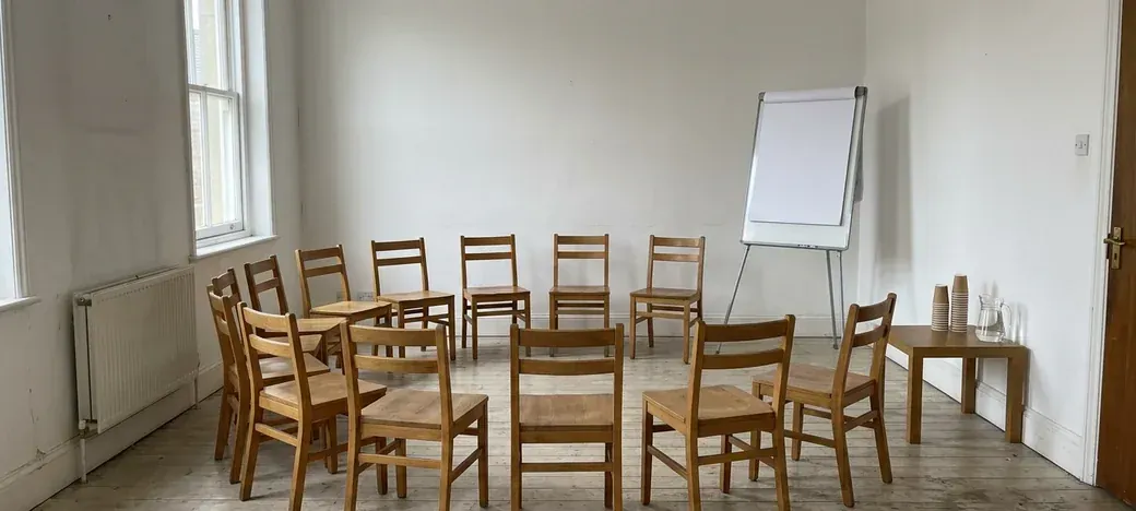 A room laid out for a workshop, chairs facing a flip chart
