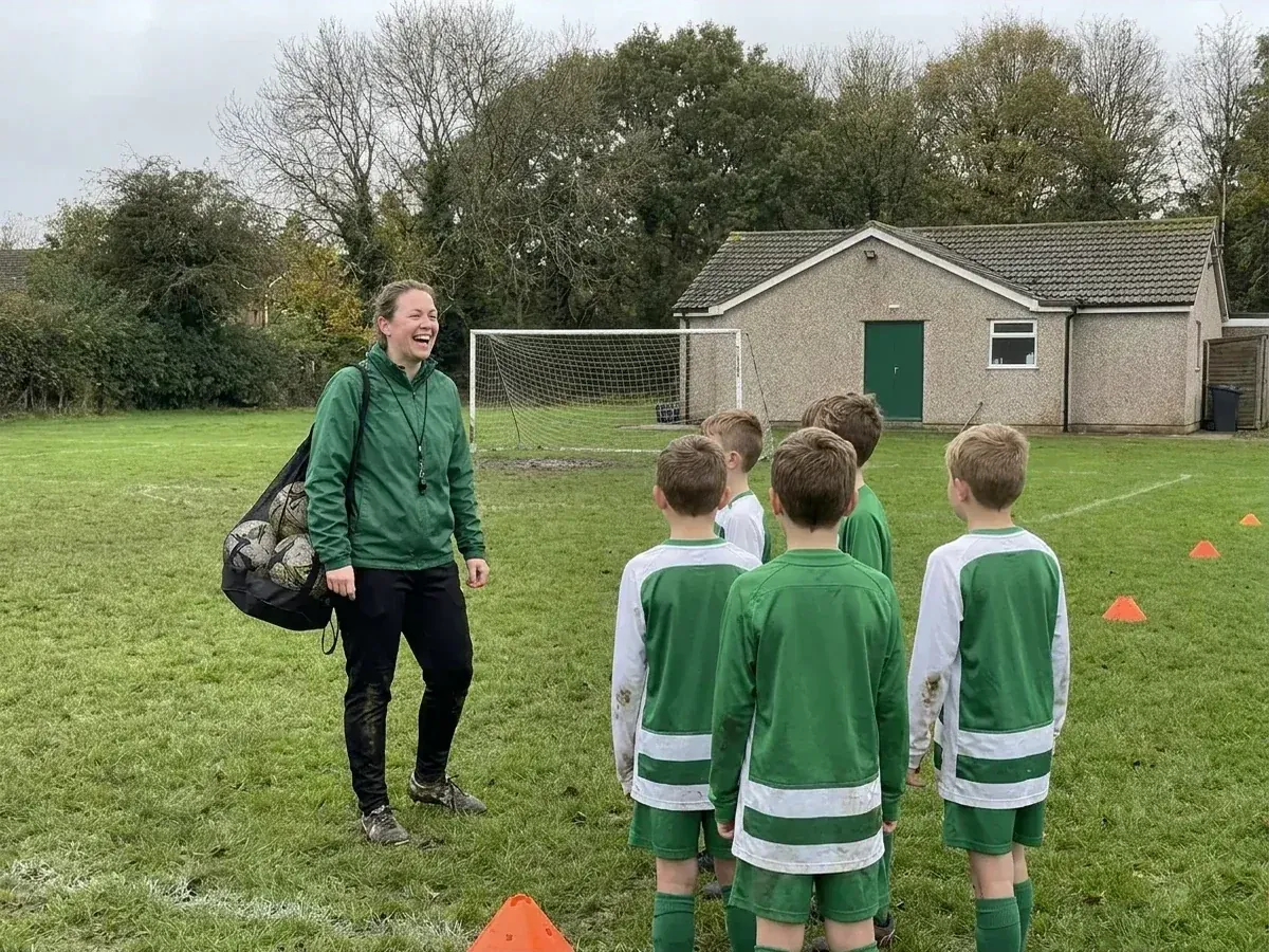 The captain of the Coppice Lane women's side laughing with the under-10s at Saturday training, the clubhouse behind them